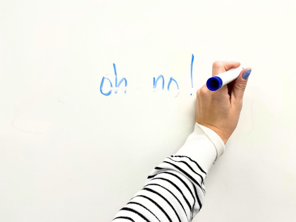 left-handed writer smeared words on a whiteboard