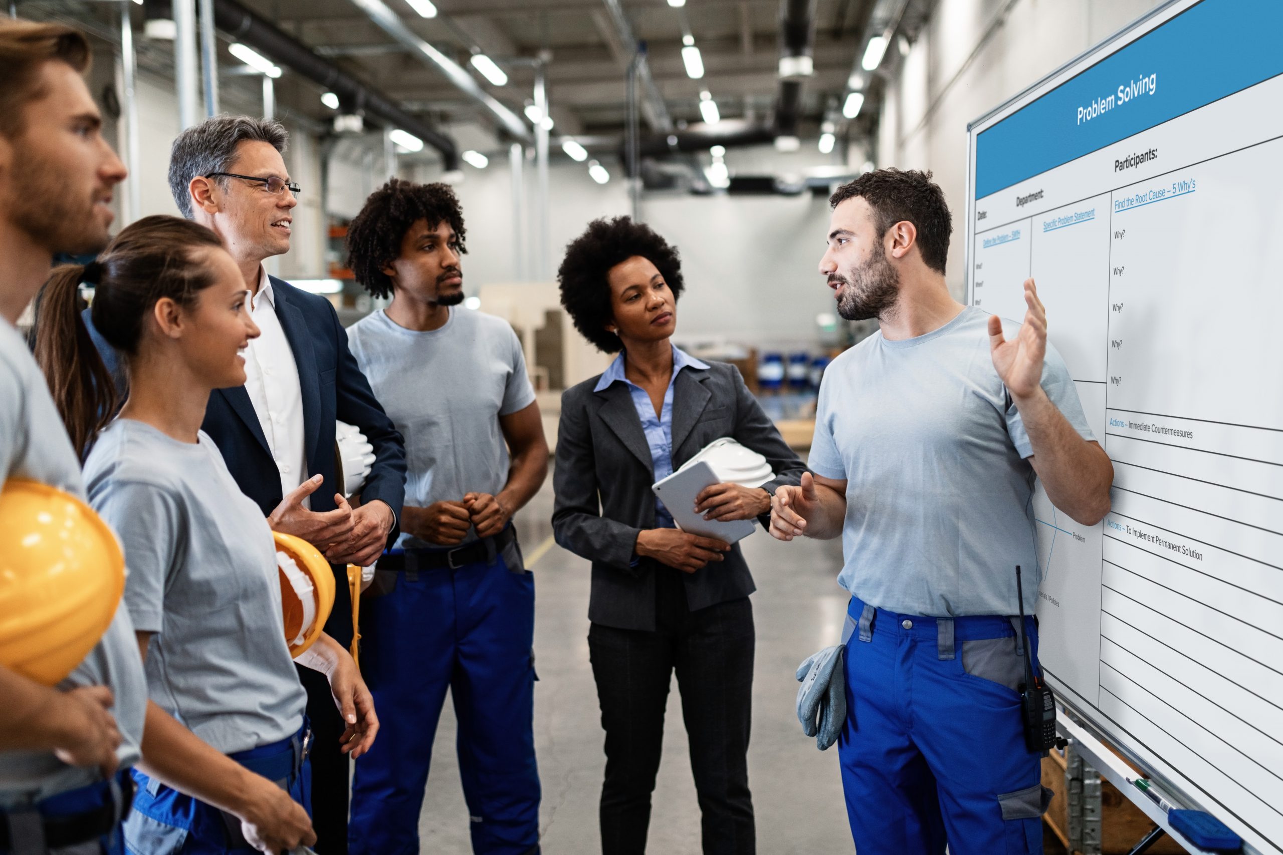 man explaining to a group of people in a manufacturing facility